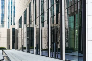 Fachada moderna de edifício comercial com esquadrias de alumínio e paredes de vidro refletindo o entorno urbano